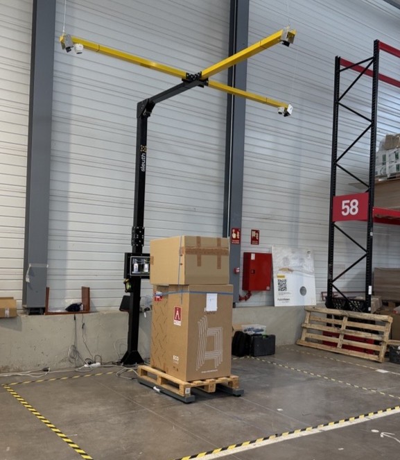 PalletVision instalado en armazém: estructura amarilla con cámaras 4K midiendo un palete con caixas
